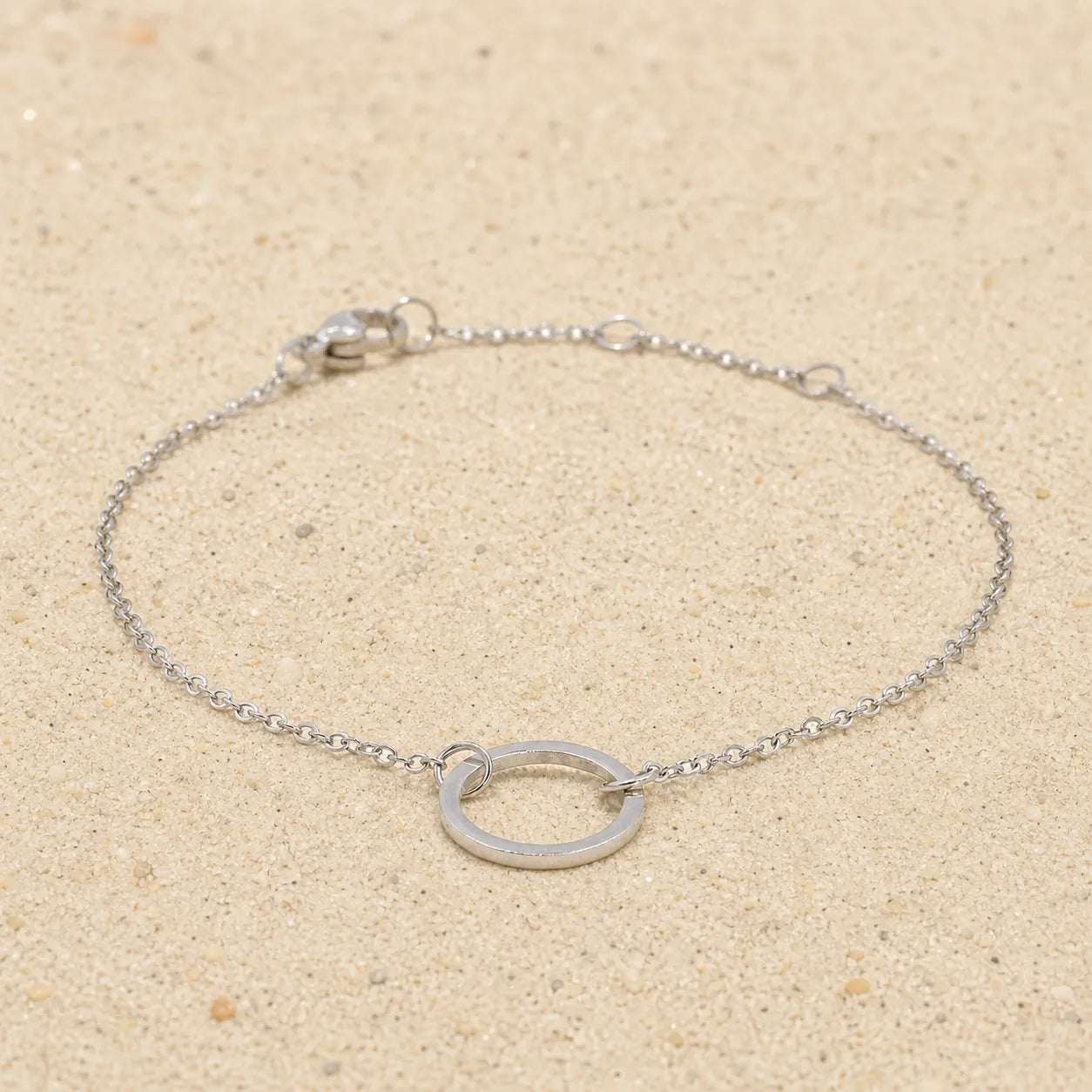 Bracelet with ring silver on light sand