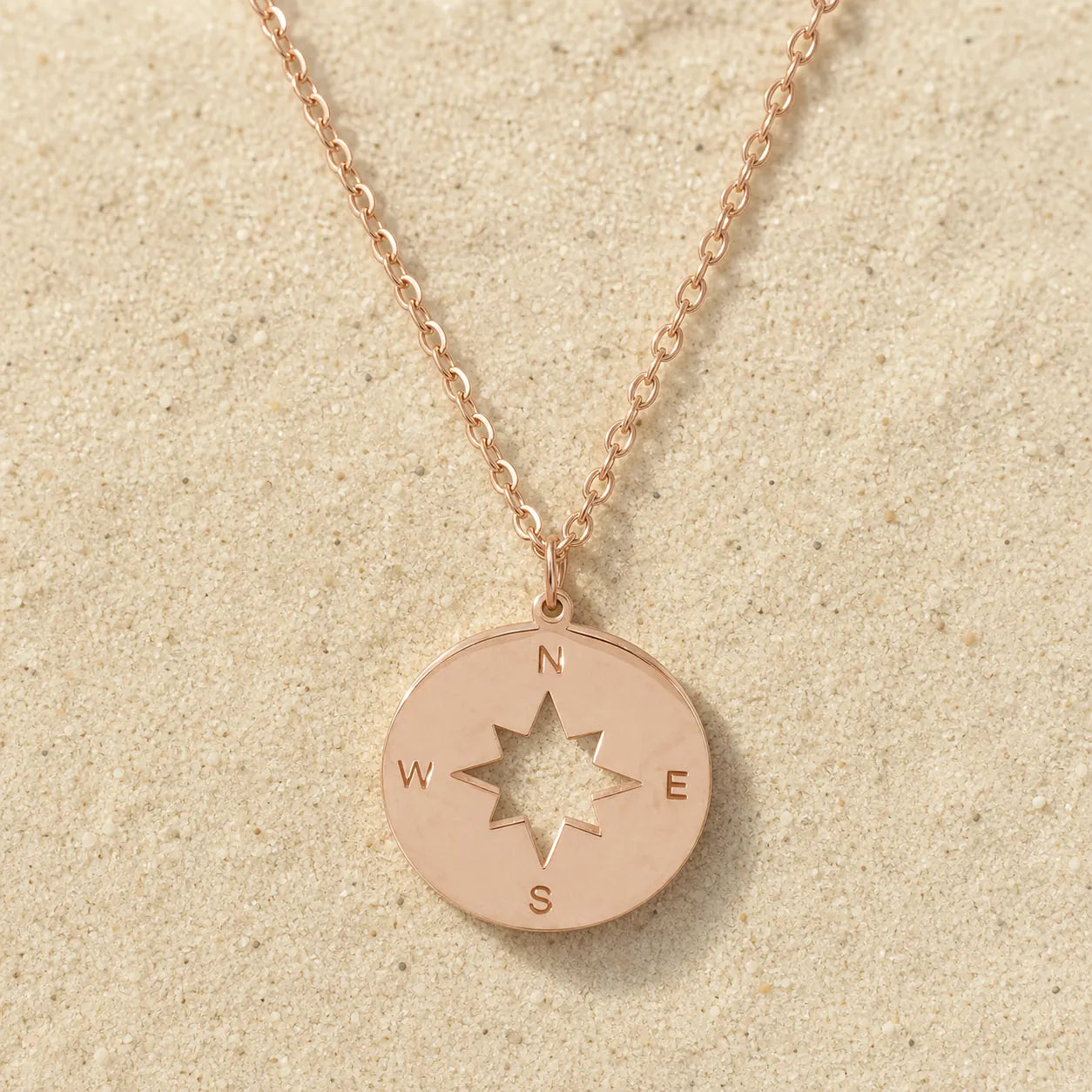 Compass Necklace Rose Gold on light sand
