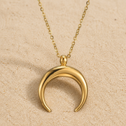 Halbmond Halskette Gold aus Edelstahl auf hellem Sand