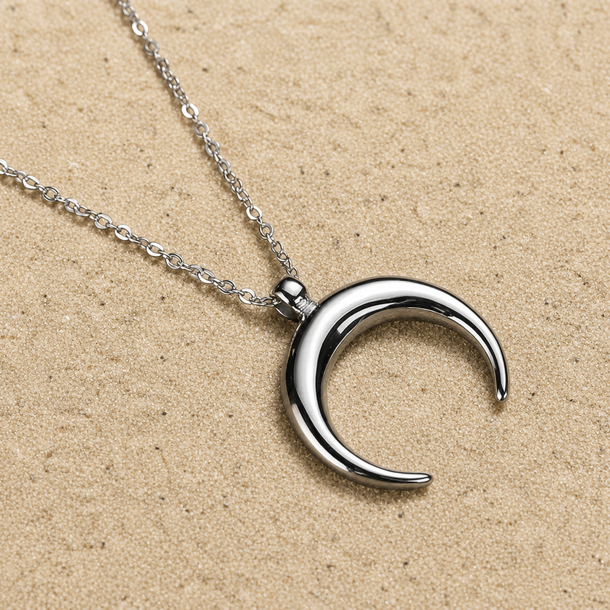 Halbmond Halskette Silber aus Edelstahl auf hellem Sand