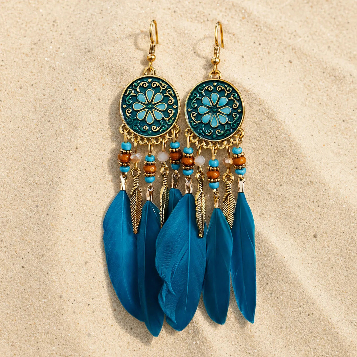 Boho Feder Ohrringe Türkis Gold auf hellem Sand