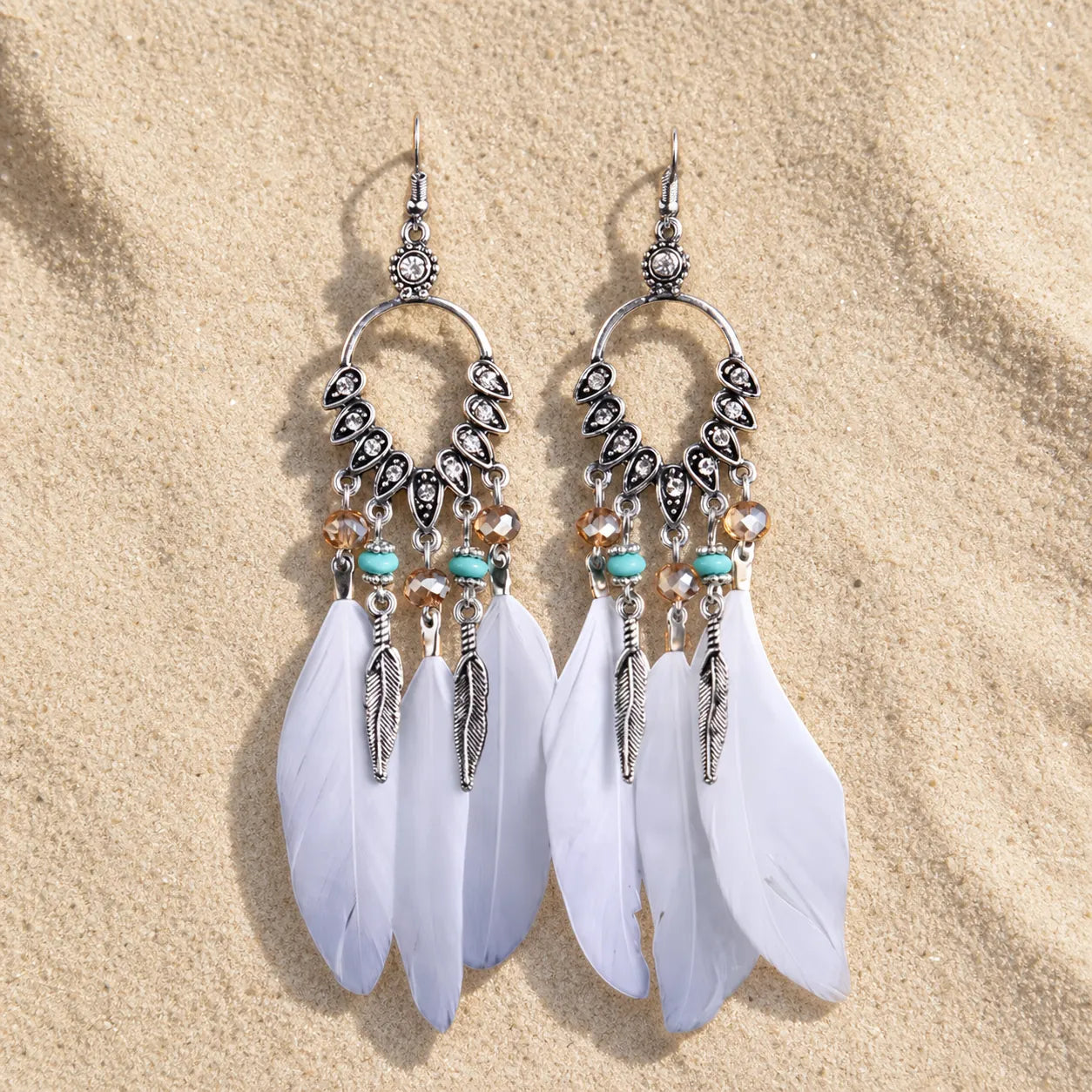 Boho Feder Ohrringe Weiß Silber auf hellem Sand