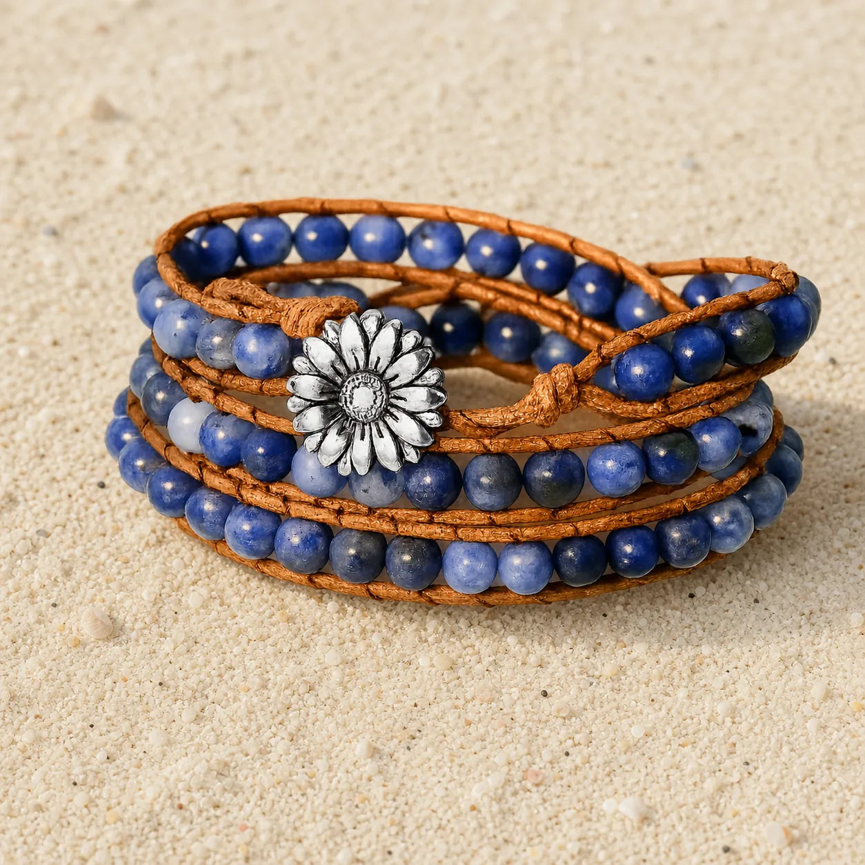 Boho Lederarmband mit blauen Natursteinperlen auf hellem Sand