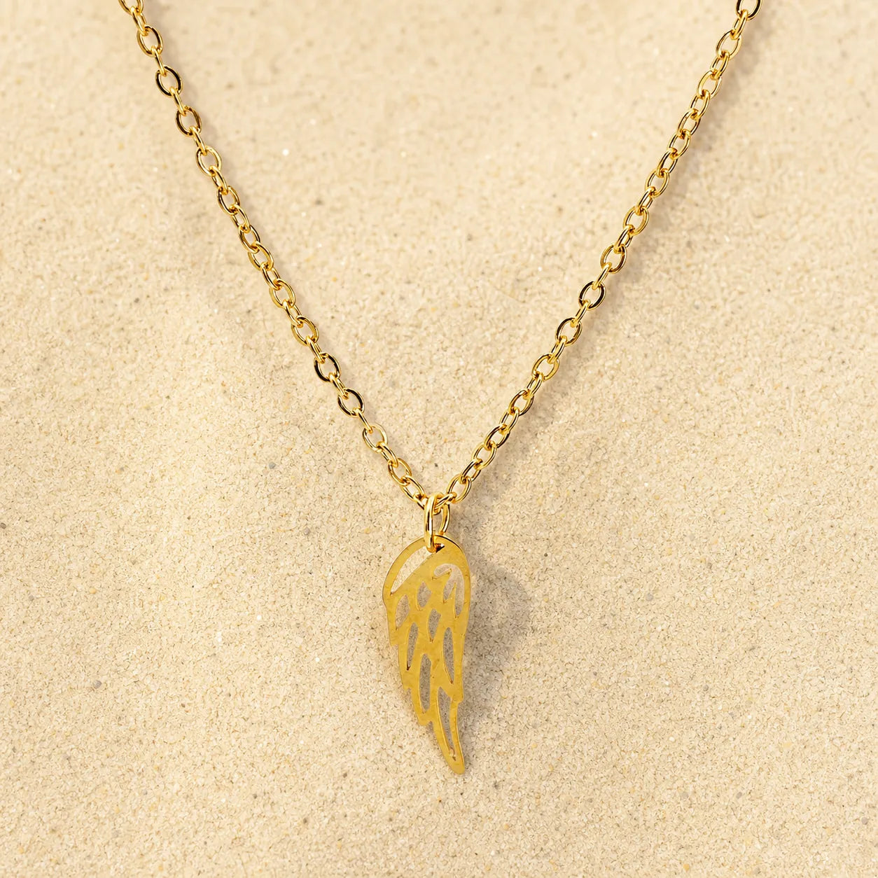 wing chain gold on light sand