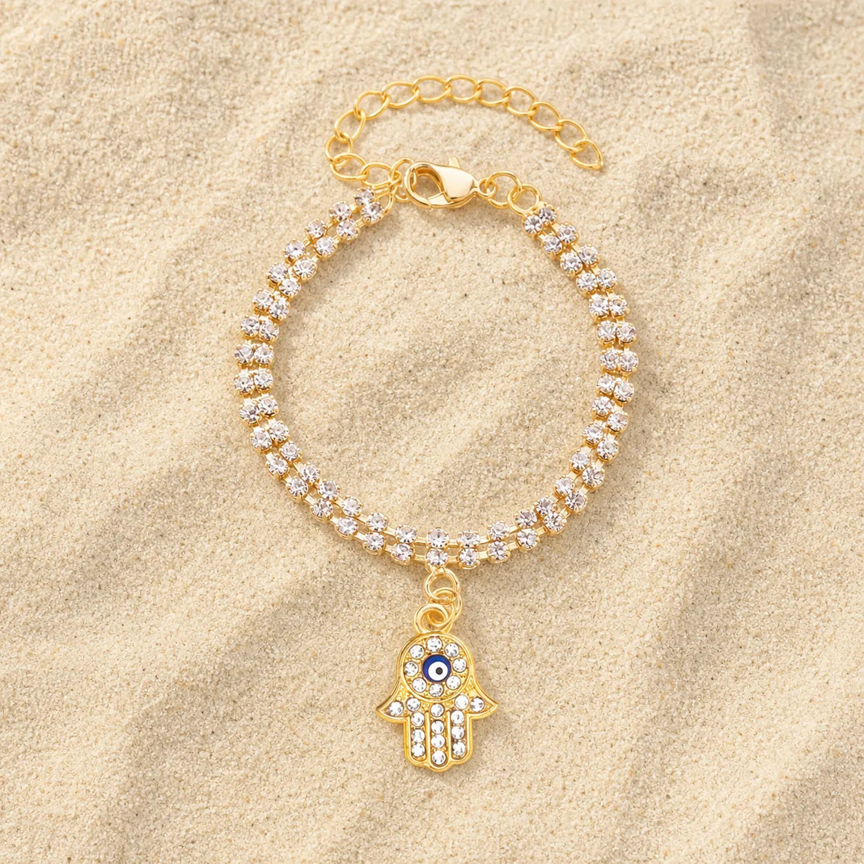 Hamsa Hand Armband Gold Zirkonia auf hellem Sand