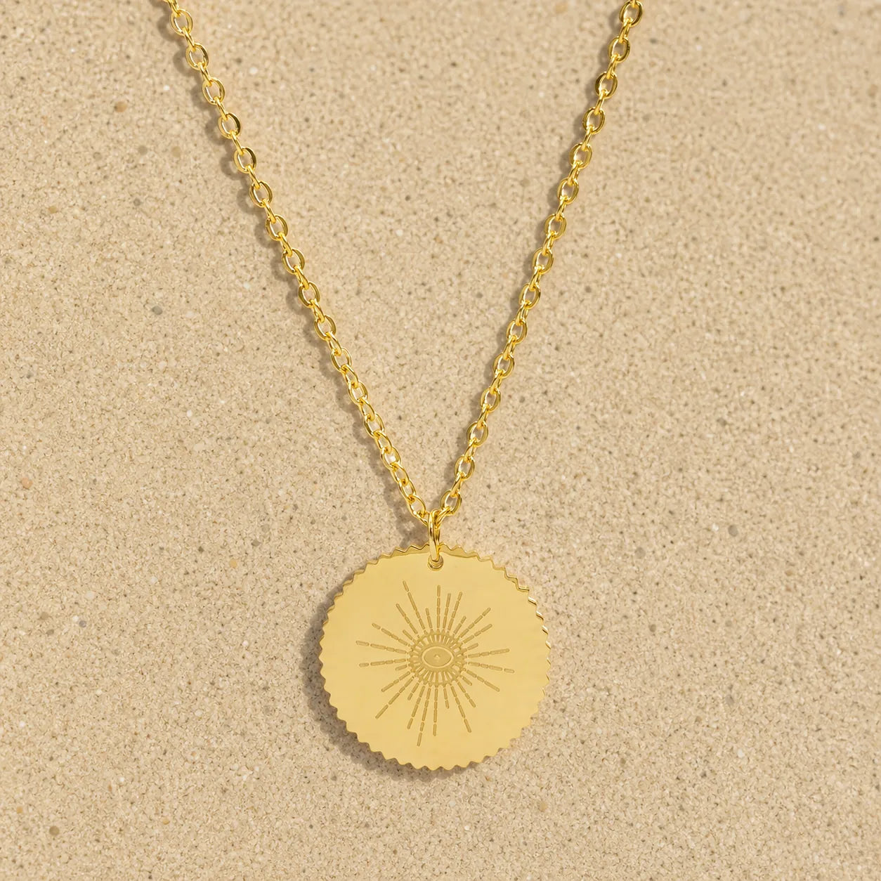 Kette mit Auge Gold auf hellem Sand