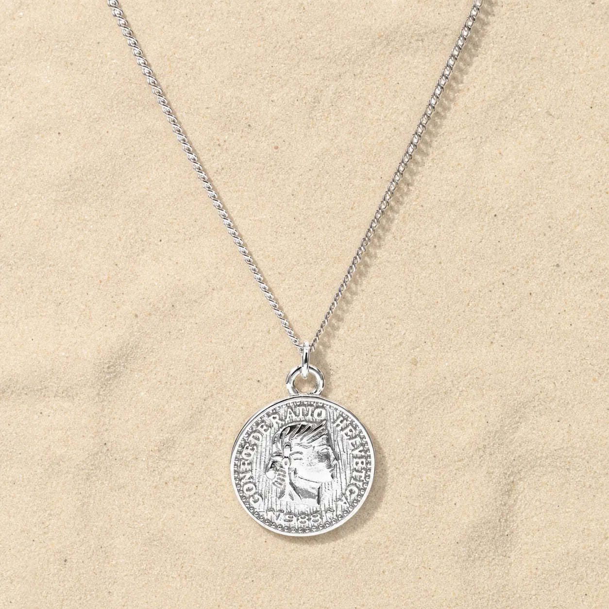 Coin chain silver on light sand