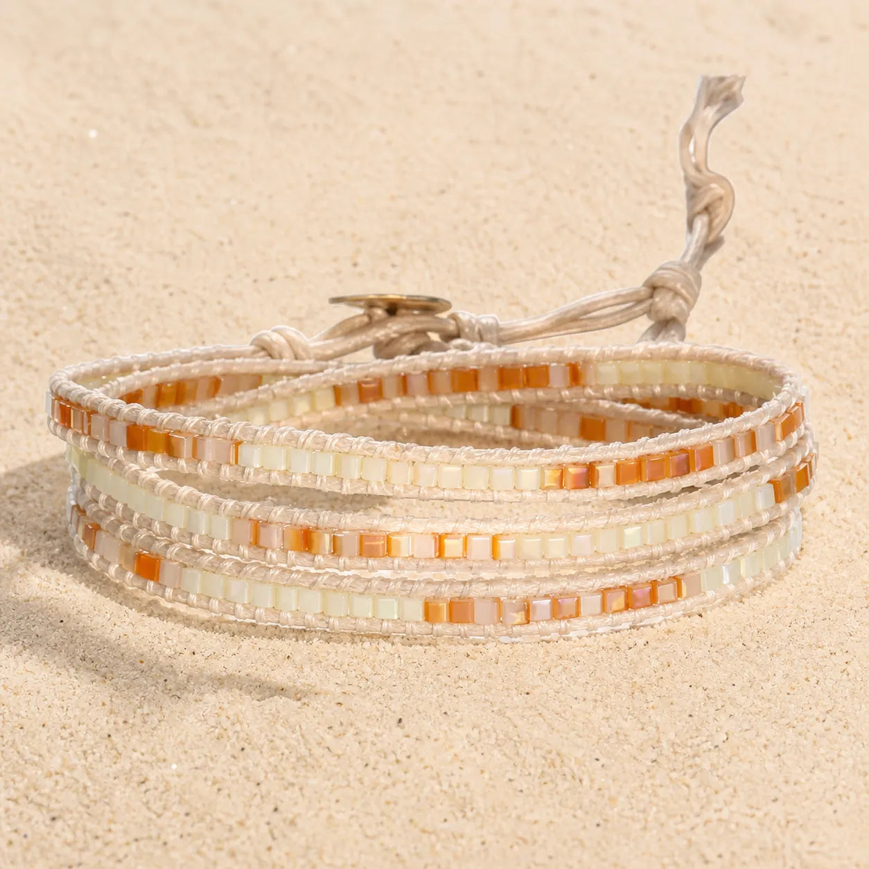 MULTILAYER WICKELARMBAND MIT STEINEN on light sand