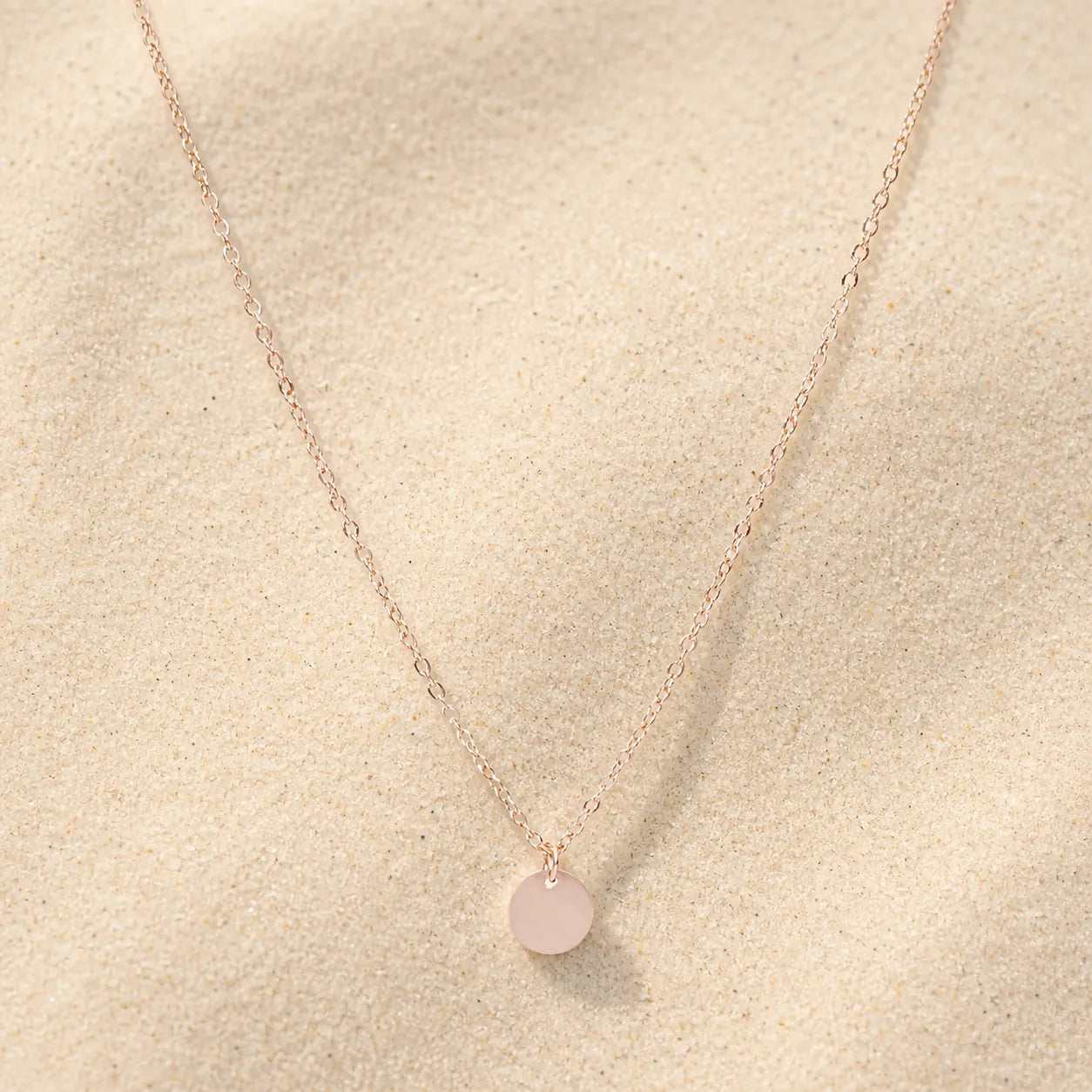 Plättchen Kette Rosegold auf hellem Sand