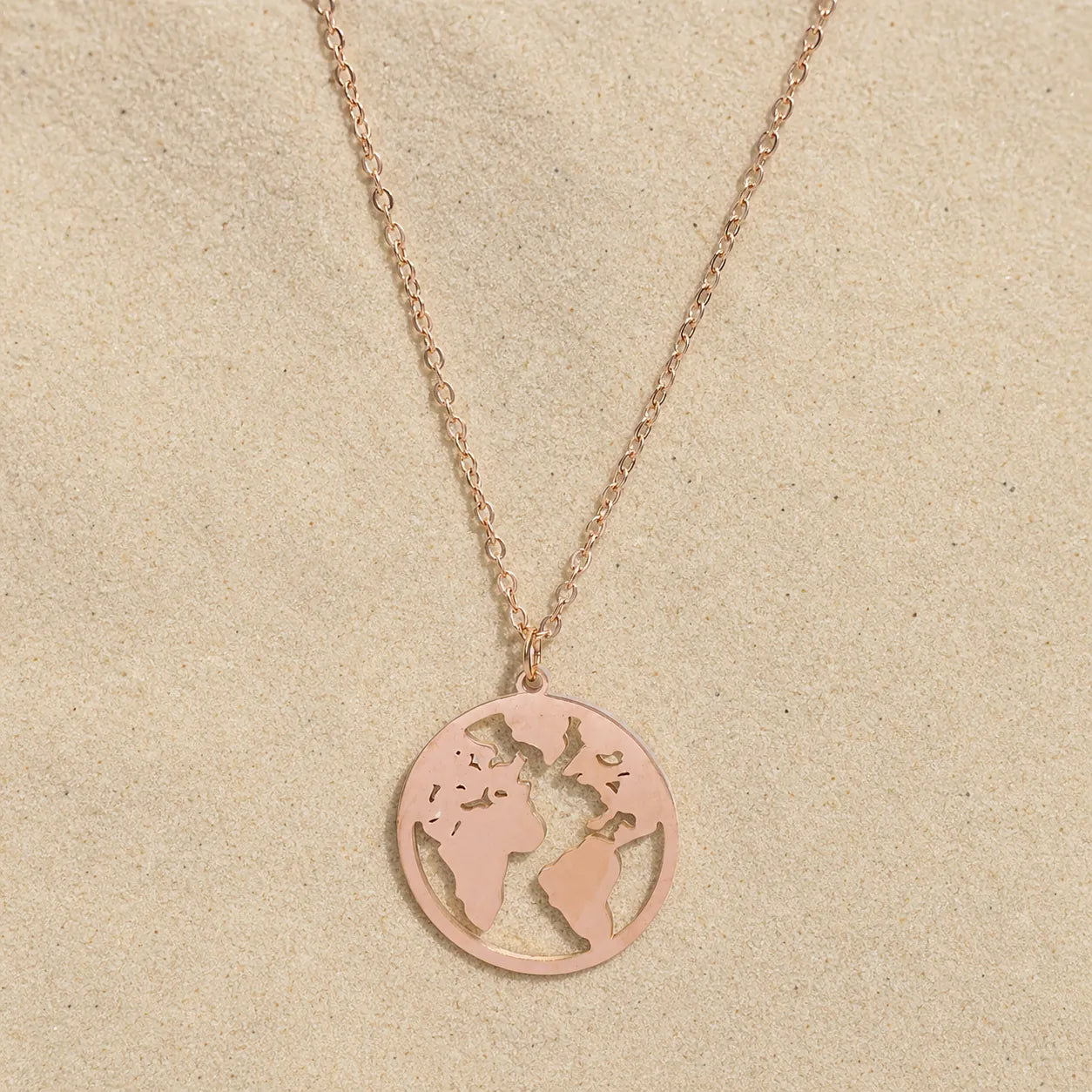 Globe Necklace Rose Gold on light sand